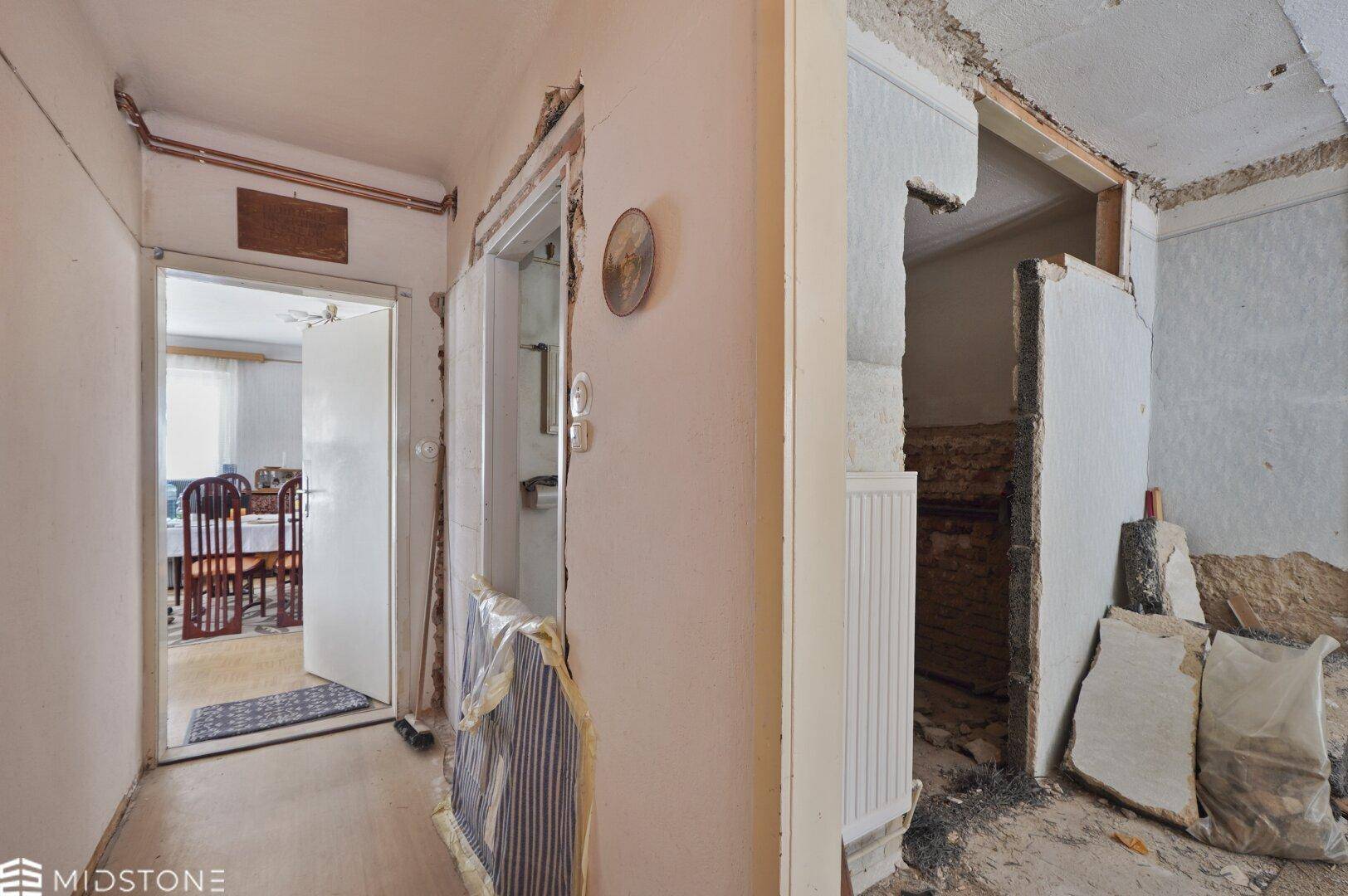 Flur mit sichtbaren Renovierungsarbeiten und Zugang zu weiteren Räumen des Hauses.