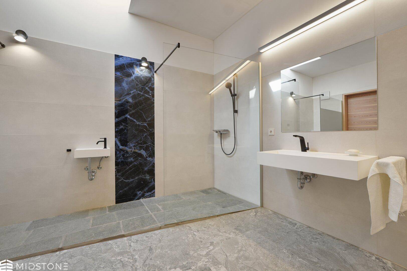 Modernes Badezimmer mit begehbarer Dusche, stilvollem Waschbecken und dunkler Akzentwand.