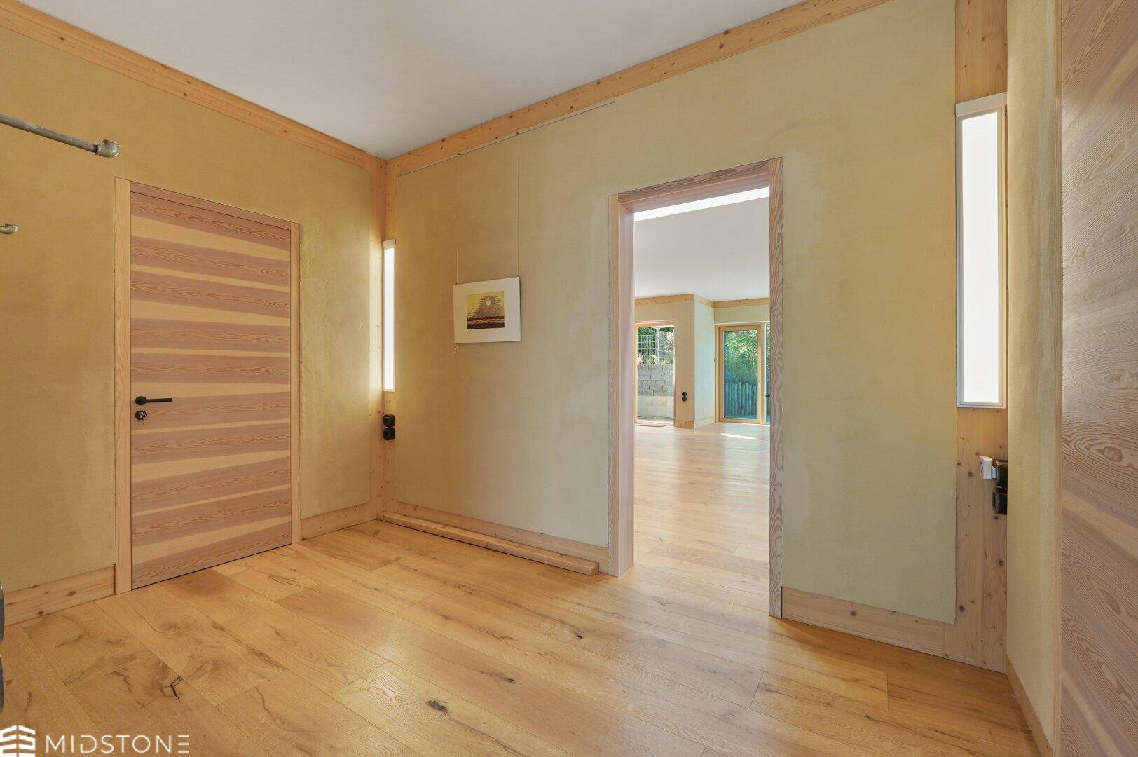 Heller Flurbereich mit Holzboden und dekorativen Holzelementen, die einen warmen Empfang bieten.