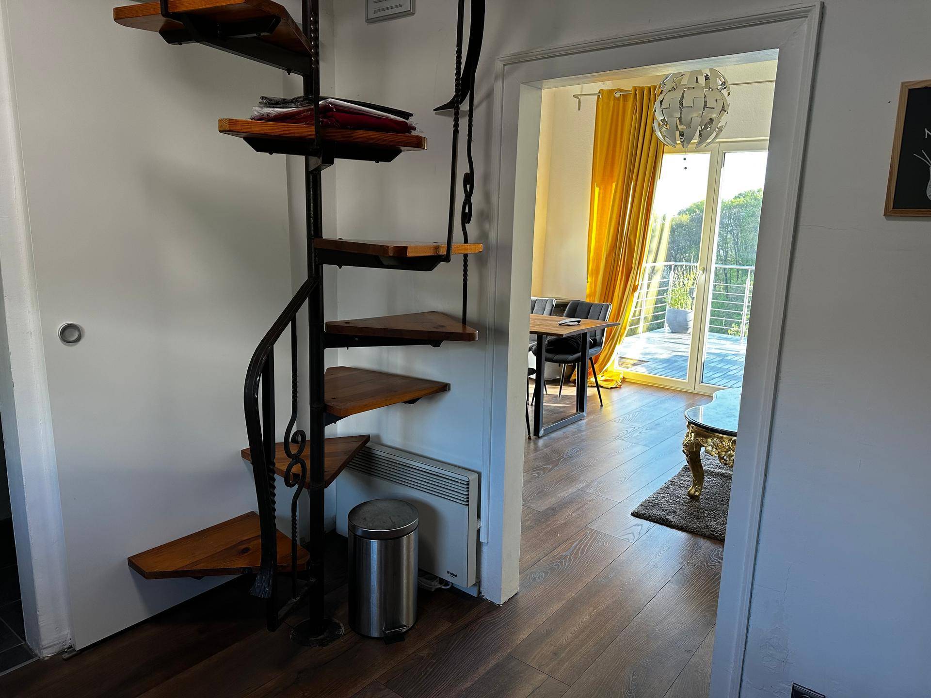 Flur mit eleganter Wendeltreppe und Blick in den hellen Wohnbereich.