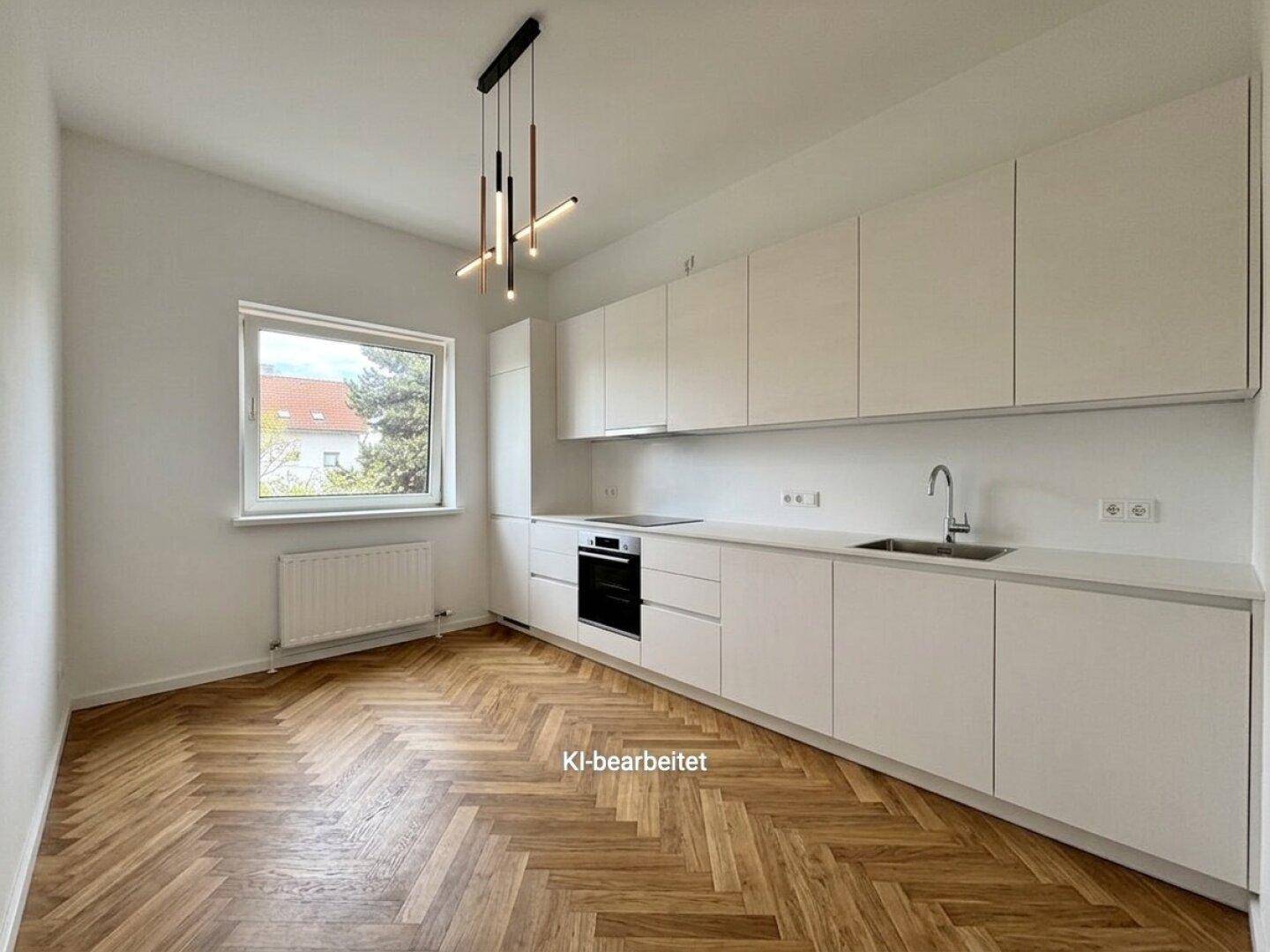 Moderne Küche mit weißen Schränken, integriertem Backofen und Fischgrätparkett, hell und funktional.