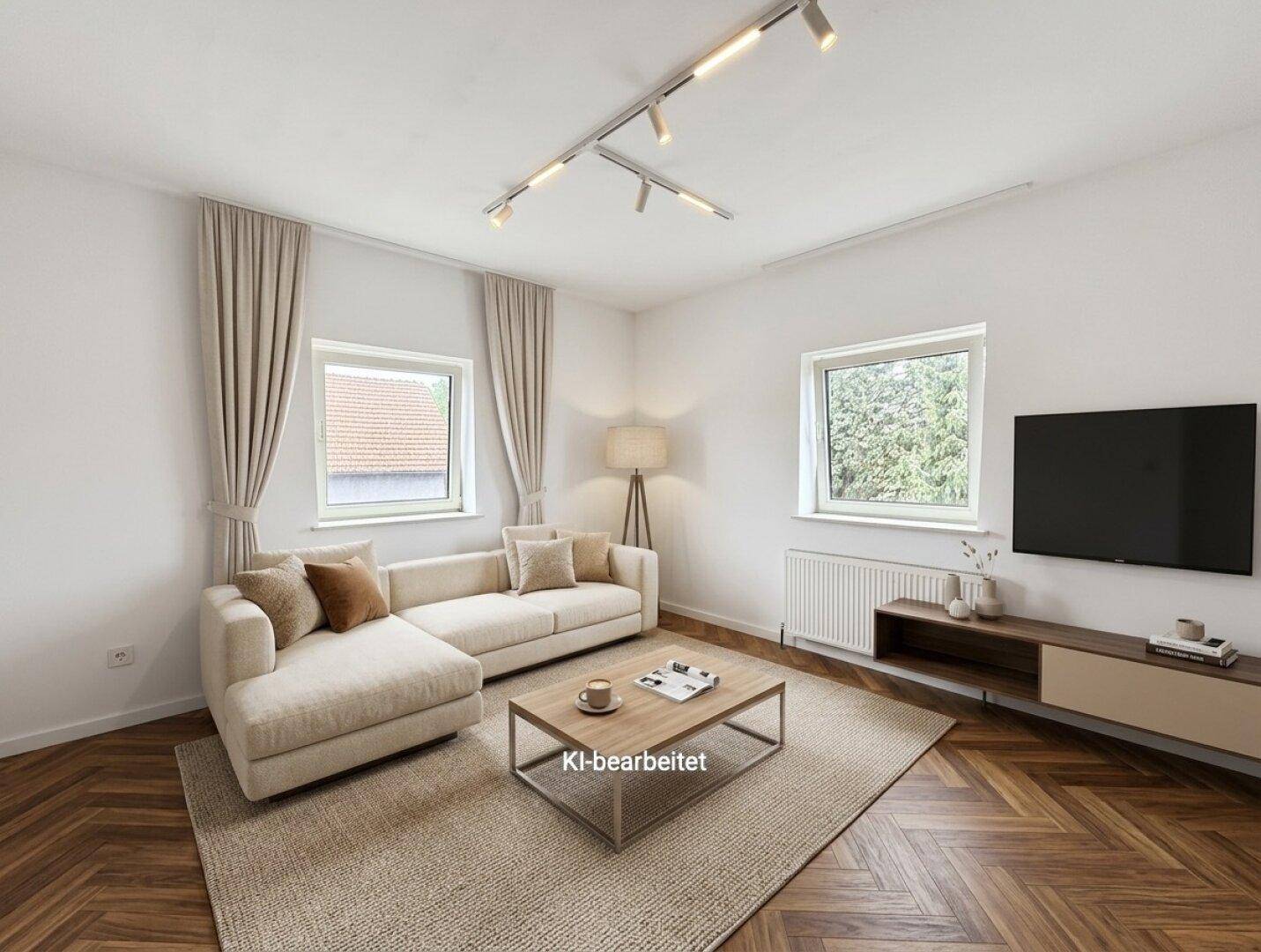 Gemütliches Wohnzimmer mit Fischgrätparkett, beigem Sofa und modernen Möbeln, hell und einladend.