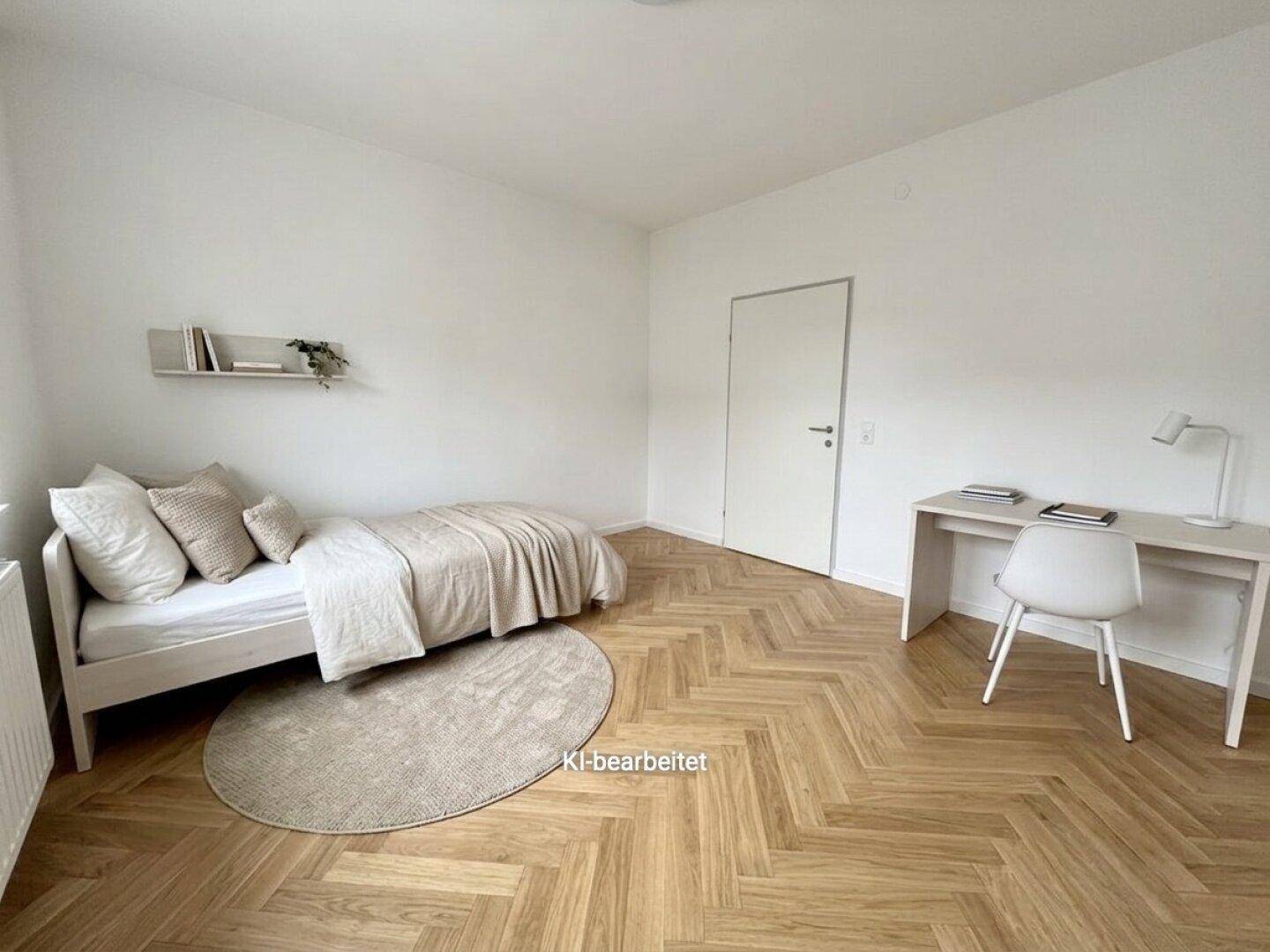 Helles Schlafzimmer mit Fischgrätparkett, Einzelbett und Schreibtisch, funktional und modern eingerichtet.