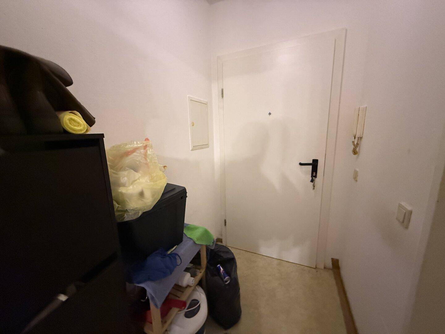 Funktionaler Eingangsbereich mit weißer Wohnungstür und Gegensprechanlage.