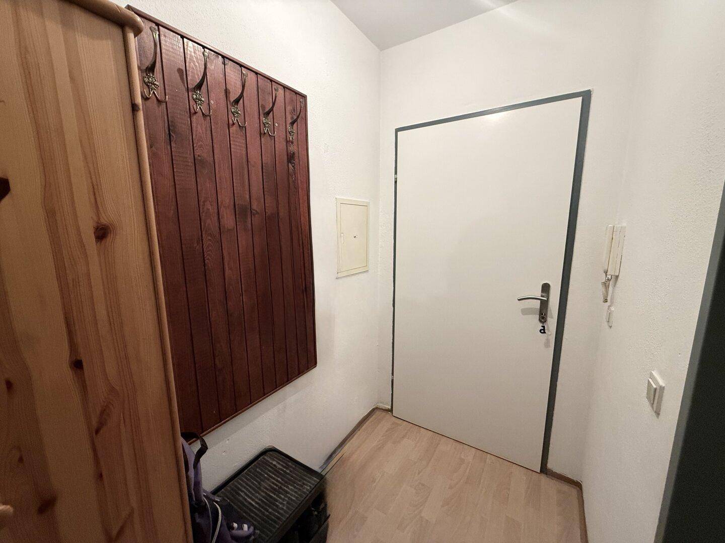 Eingangsbereich mit Garderobe und heller Laminatboden.
