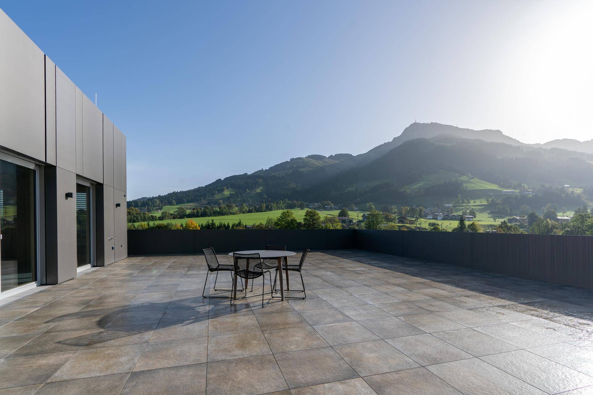 Weitläufige Dachterrasse mit Sitzgruppe und beeindruckendem Panoramablick auf die Berge und Täler.