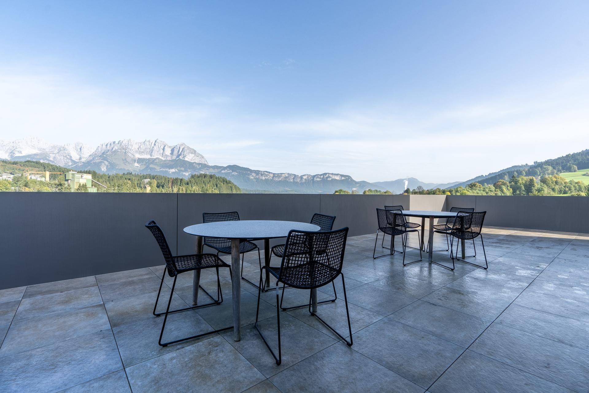 Große Dachterrasse mit mehreren Sitzgruppen und einem atemberaubenden Blick auf die umliegende Berglandschaft.