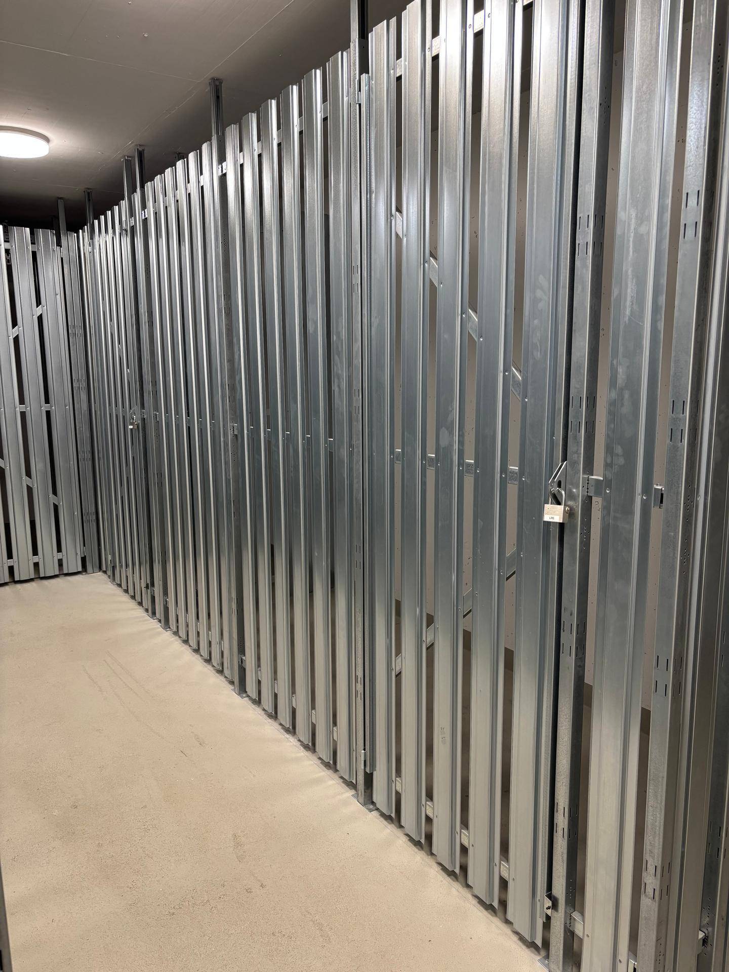 Reihe von individuellen Lagerräumen mit robusten Metallwänden und sicherem Vorhängeschloss, in neuwertigem Zustand.