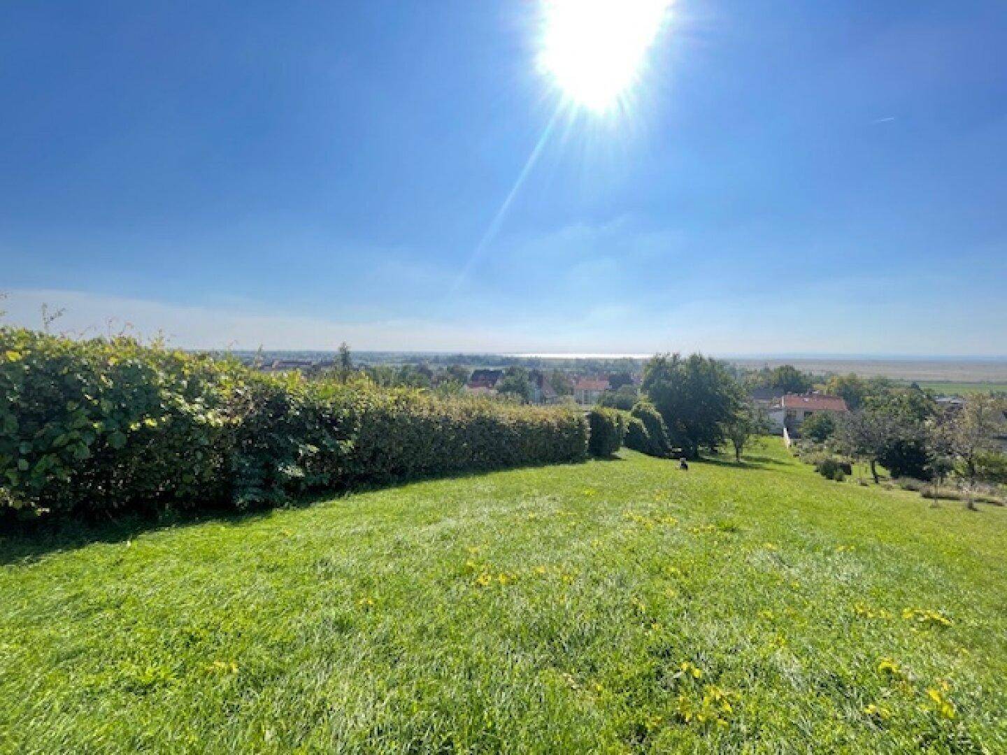 Weitläufige Grünfläche mit Panoramablick über die Landschaft und eine ferne Stadt.