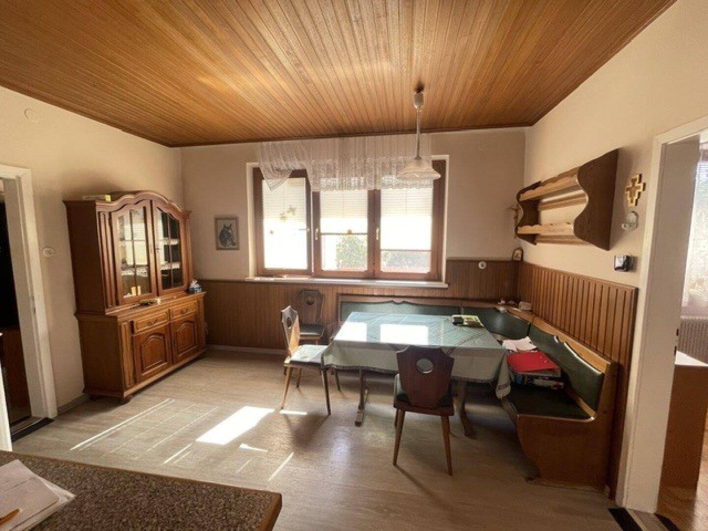 Essbereich mit traditioneller Eckbank, Holztisch und Holzdecke, ideal für Familienmahlzeiten.