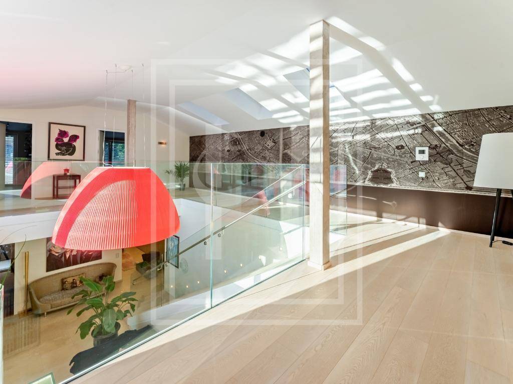 Heller Flur mit moderner Glasgeländer-Treppe, Holzboden und einer stilvollen Wandkarte als Dekoration.