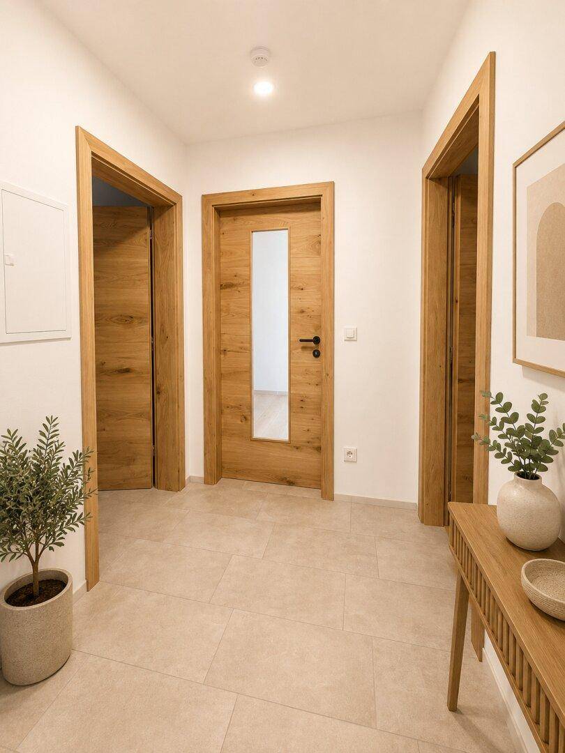 Heller Flur mit modernen Holztüren und Fliesenboden, der zu verschiedenen Räumen der Wohnung führt.