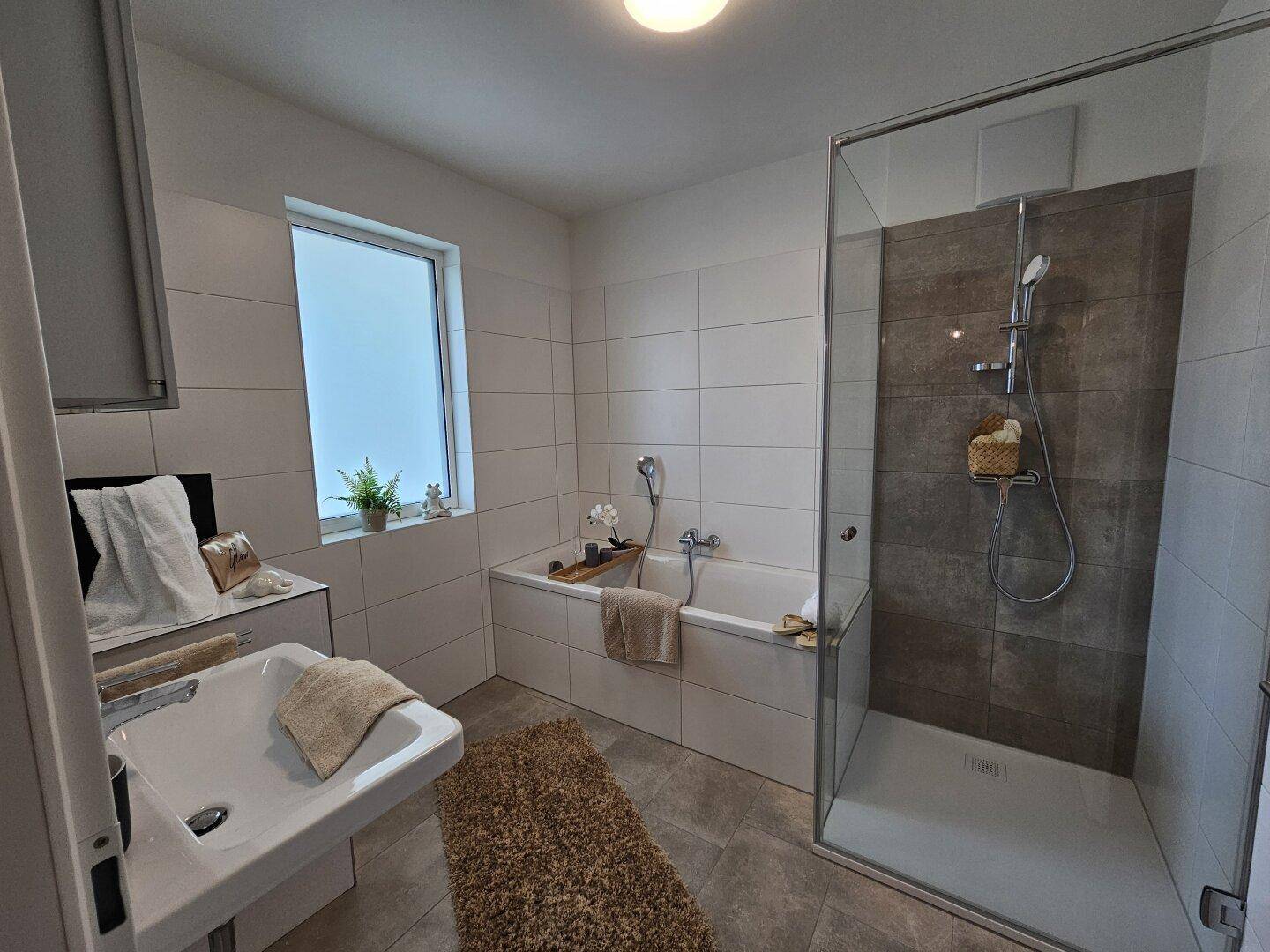 Modernes Badezimmer mit Badewanne, begehbarer Dusche, Einzelwaschbecken und Fenster.