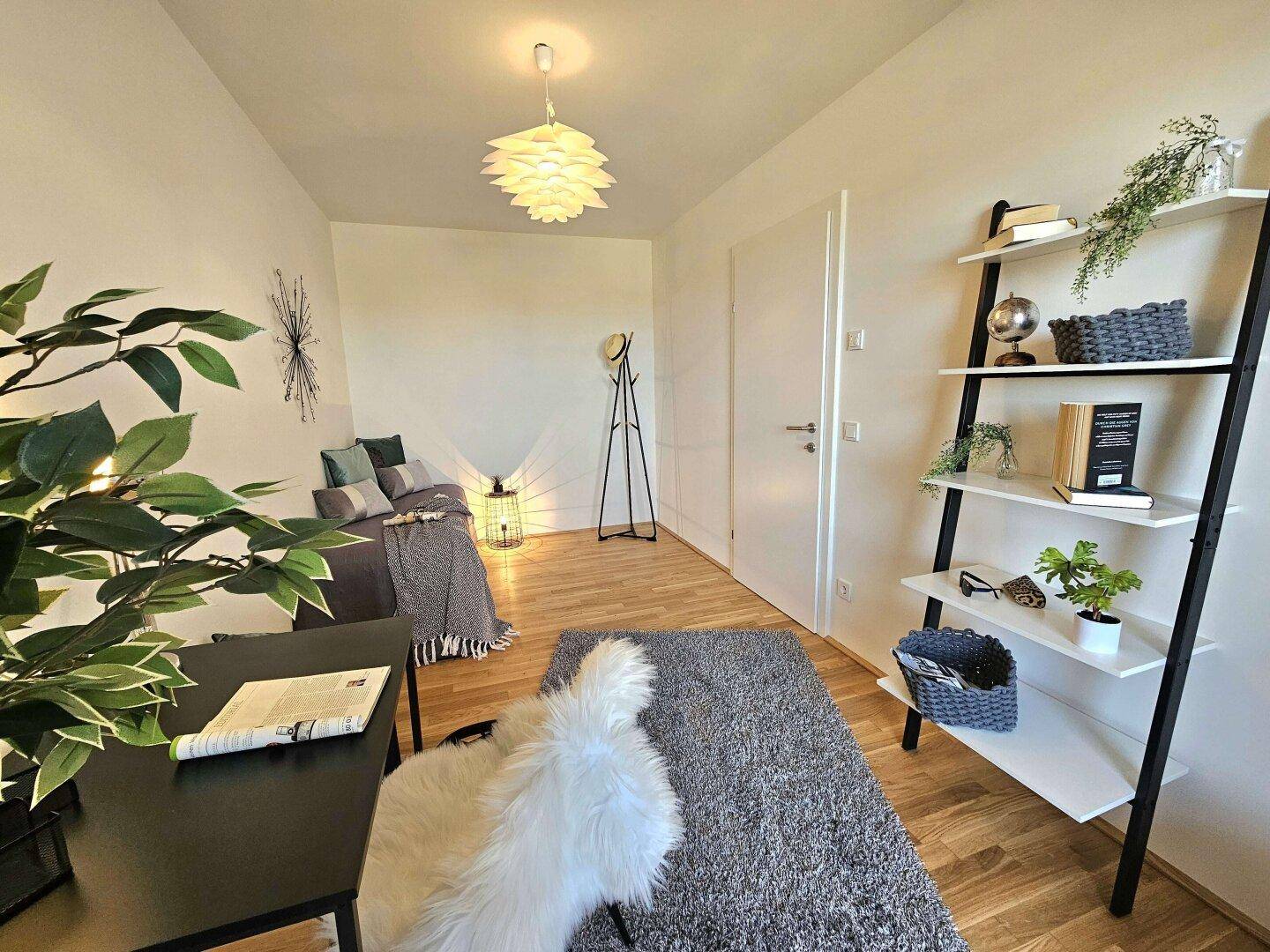 Gemütliches Schlafzimmer oder Gästezimmer mit Holzboden und modernem Regal.