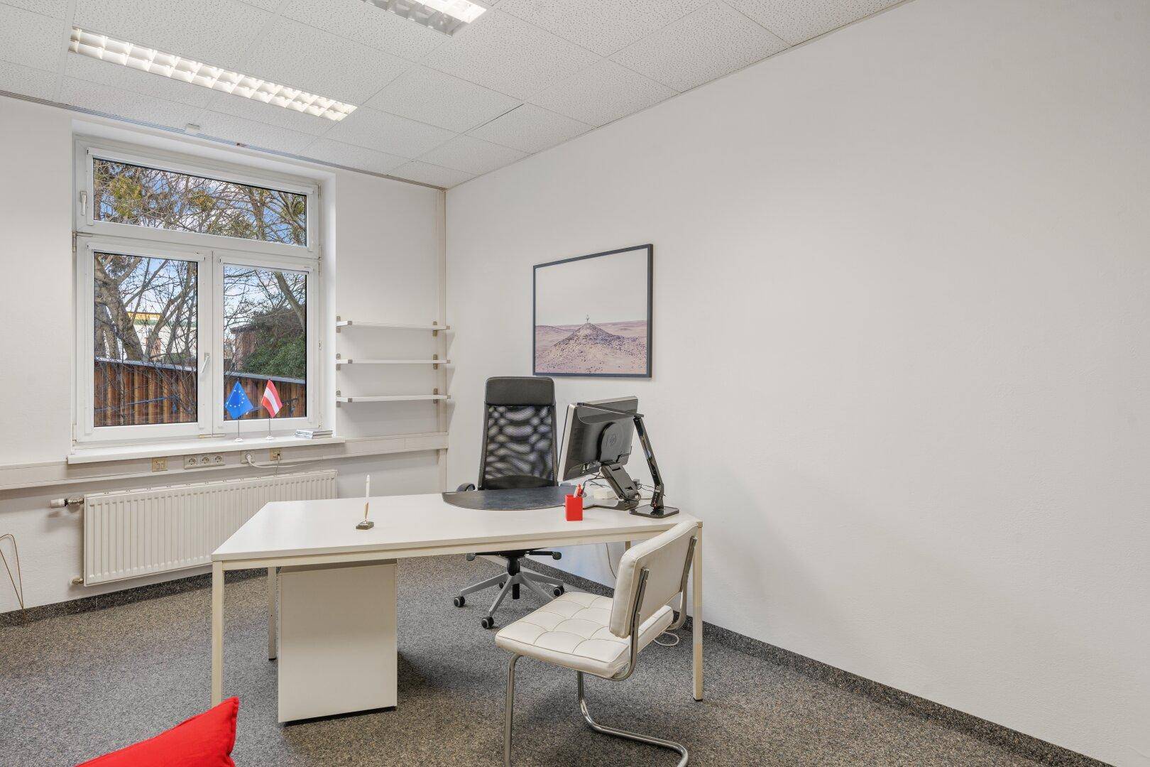 Einzelbüro mit Schreibtisch, Bürostuhl und Regalen, bietet eine ruhige Arbeitsumgebung mit Tageslicht.