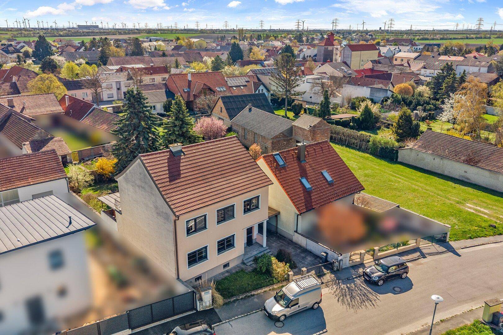 Weitläufige Luftaufnahme der Wohnsiedlung mit Einfamilienhäusern und Grünflächen.