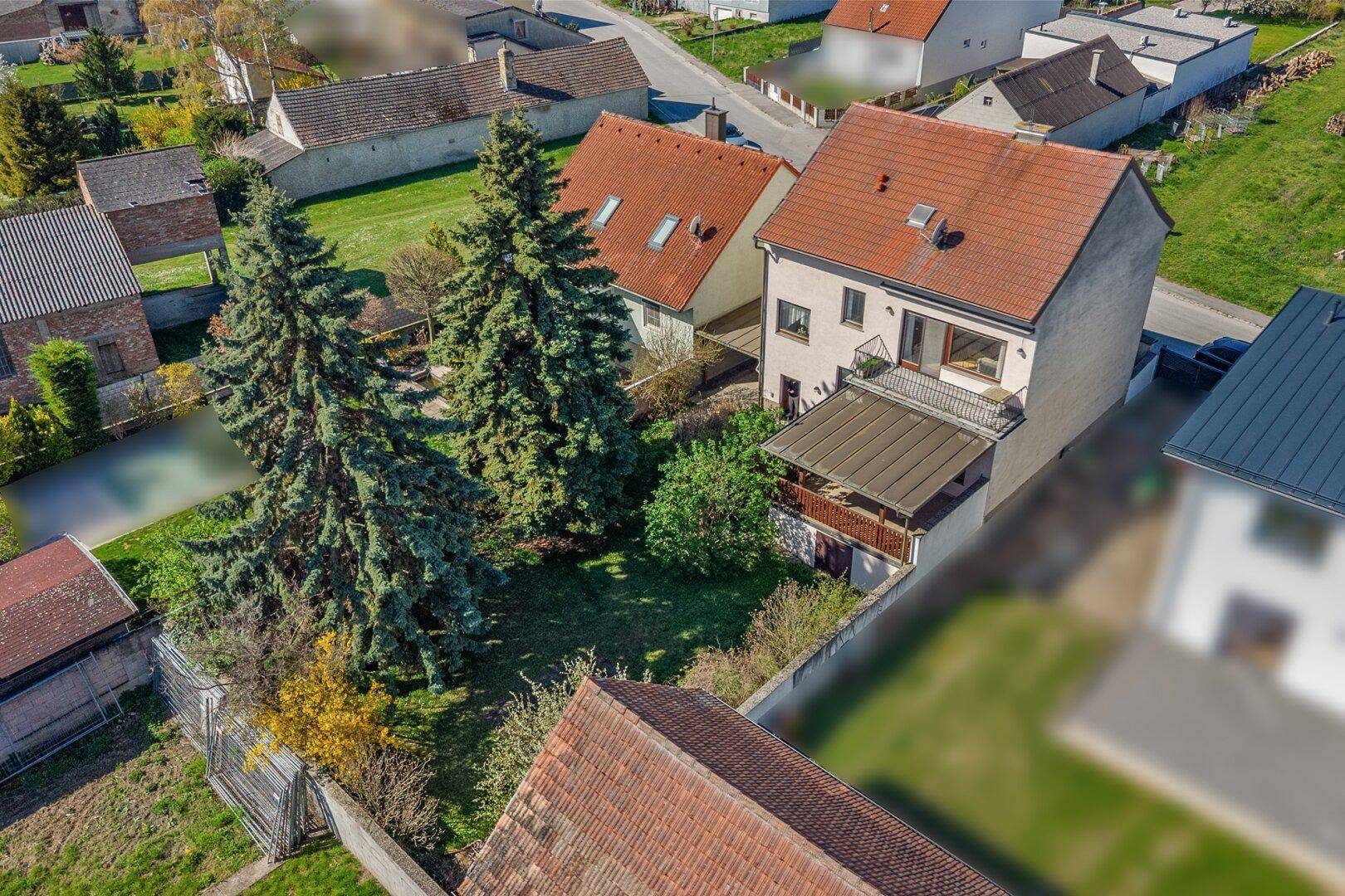 Luftaufnahme des Einfamilienhauses mit Garten und umliegender Wohnbebauung.