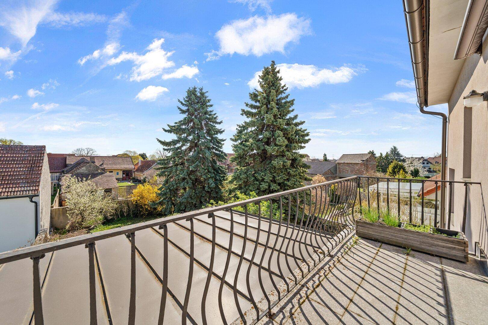 Balkon mit schmiedeeisernem Geländer und weitem Blick über die Nachbarschaft.
