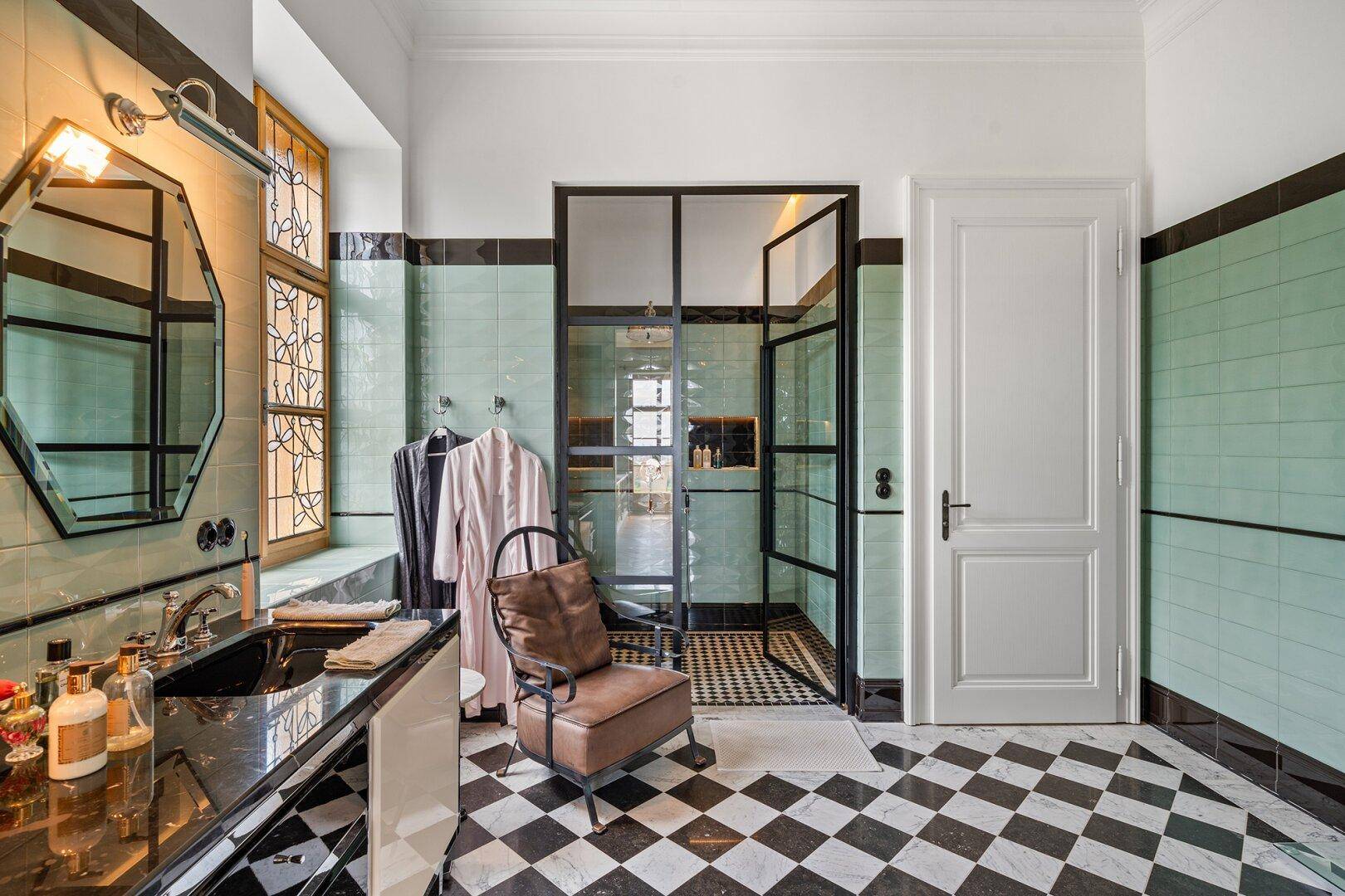 Stilvolles Badezimmer mit großer Dusche, Doppelwaschbecken und eleganten Fliesen.