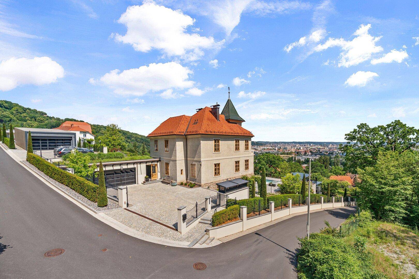 Elegantes Anwesen mit Zufahrt, Doppelgarage und Panoramablick über die Stadt.