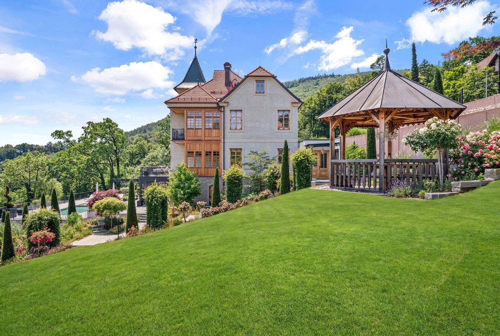 Herrschaftliches Anwesen mit gepflegtem Garten, Pavillon und Blick auf die umliegende Landschaft.