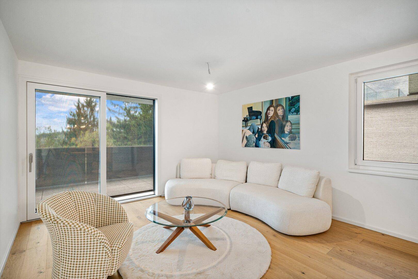 Helles Wohnzimmer mit weißem Sofa, Holzboden und Zugang zu einem großen Balkon.