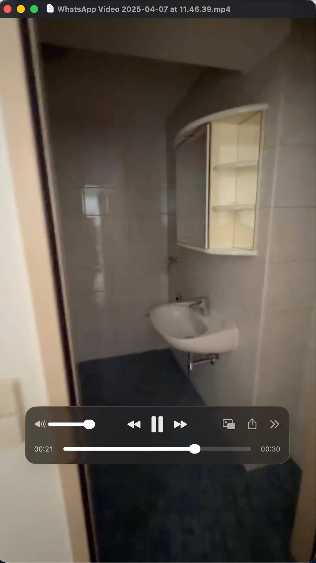 Kleines Gäste-WC mit Waschbecken, Fliesen und Spiegelschrank, praktisch und sauber.