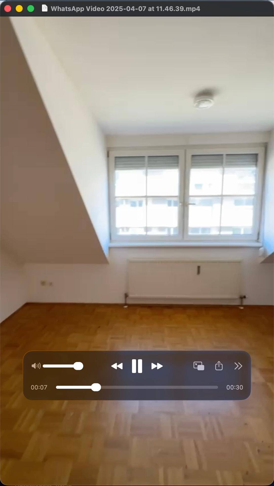 Heller Raum mit Fenster, Dachschräge und Parkettboden, bietet viel Tageslichteinfall.