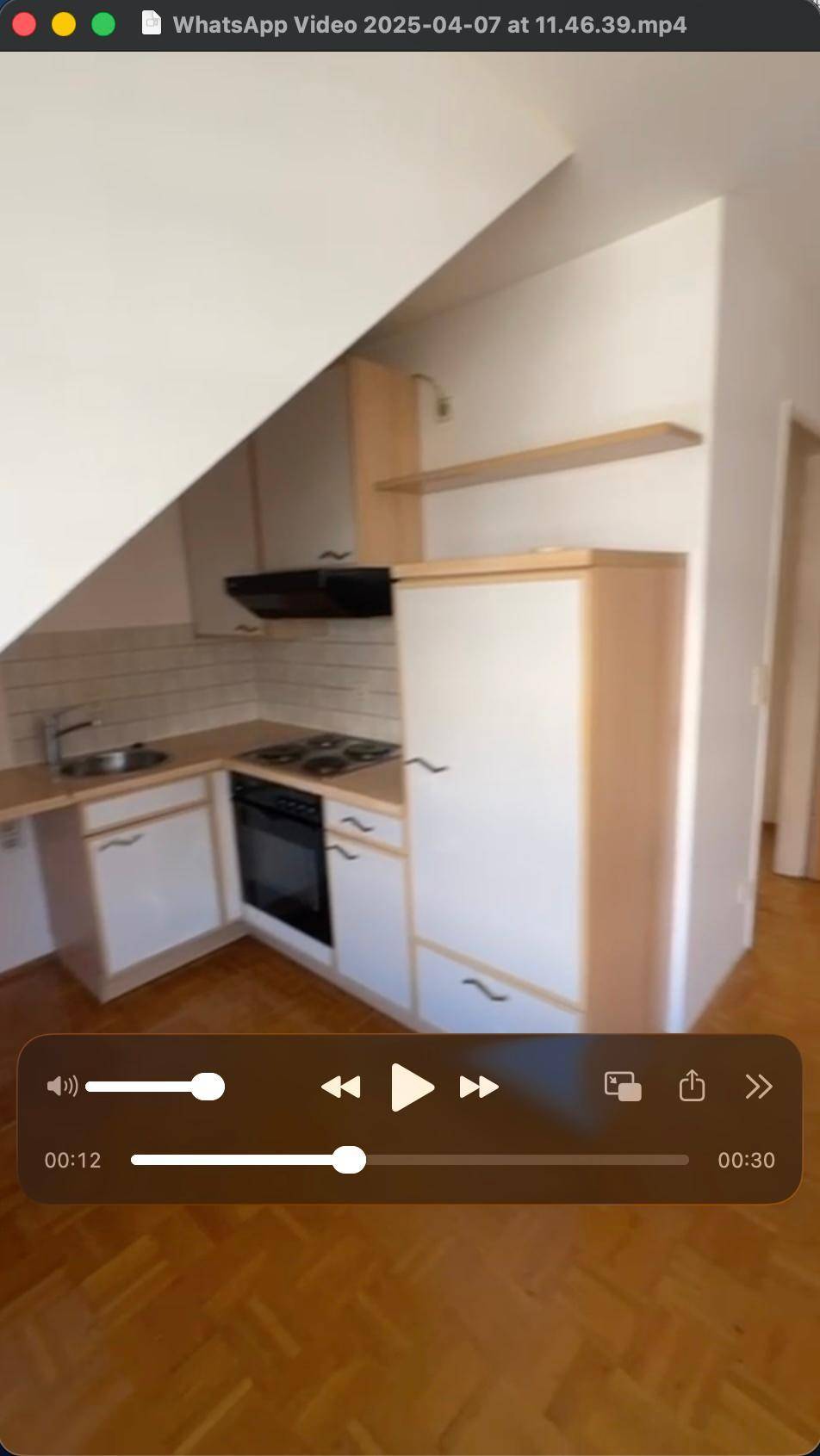 Kleine Einbauküche mit Dachschräge, Herd und Spüle, funktional und hell gestaltet.