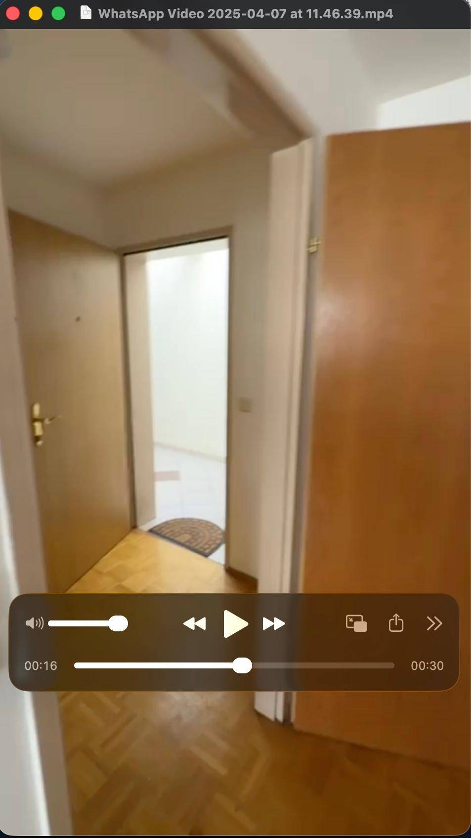 Flur mit Holztüren und Parkettboden, verbindet verschiedene Räume der Wohnung miteinander.