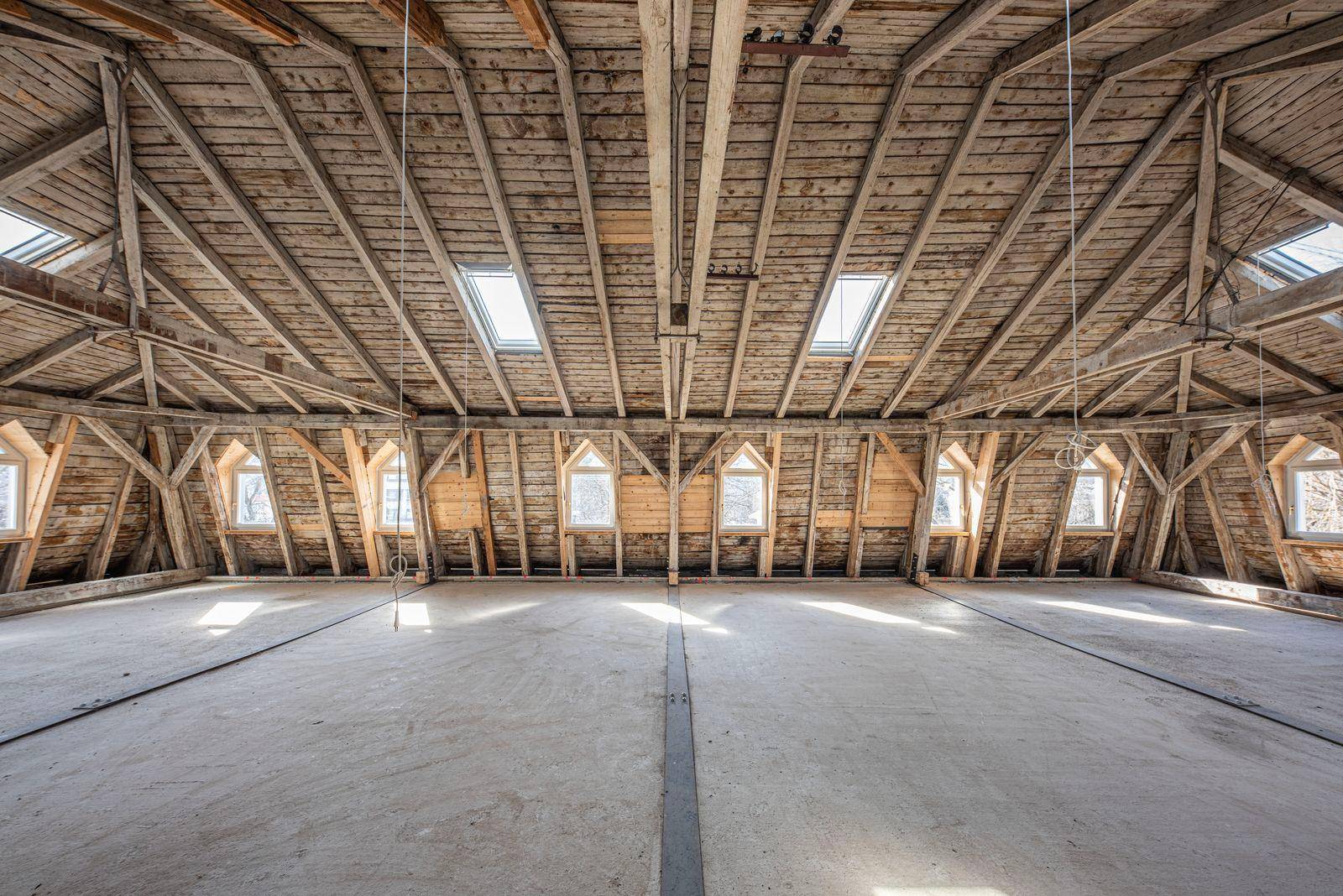 Geräumiger Dachboden mit Holzdachkonstruktion und mehreren Dachfenstern, ideal für zukünftige Nutzung.