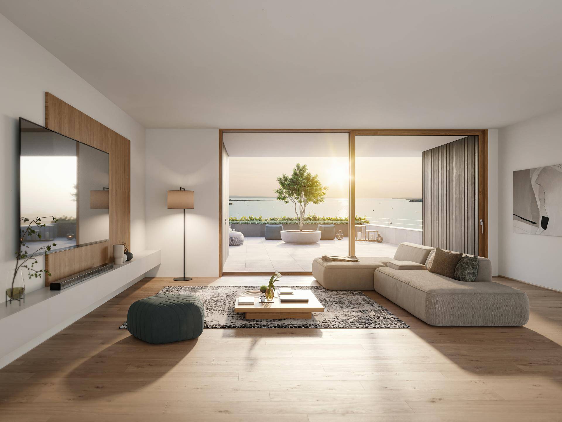 Moderner Wohnraum mit bequemer Couch und großen Glasfronten, die einen weiten Seeblick bieten.