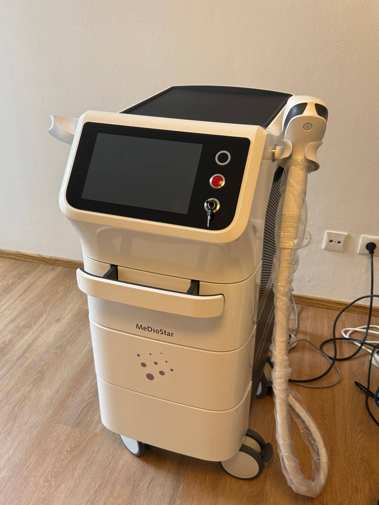Modernes MeDioStar-Gerät für ästhetische Behandlungen auf einem Laminatboden in einem hellen Raum.