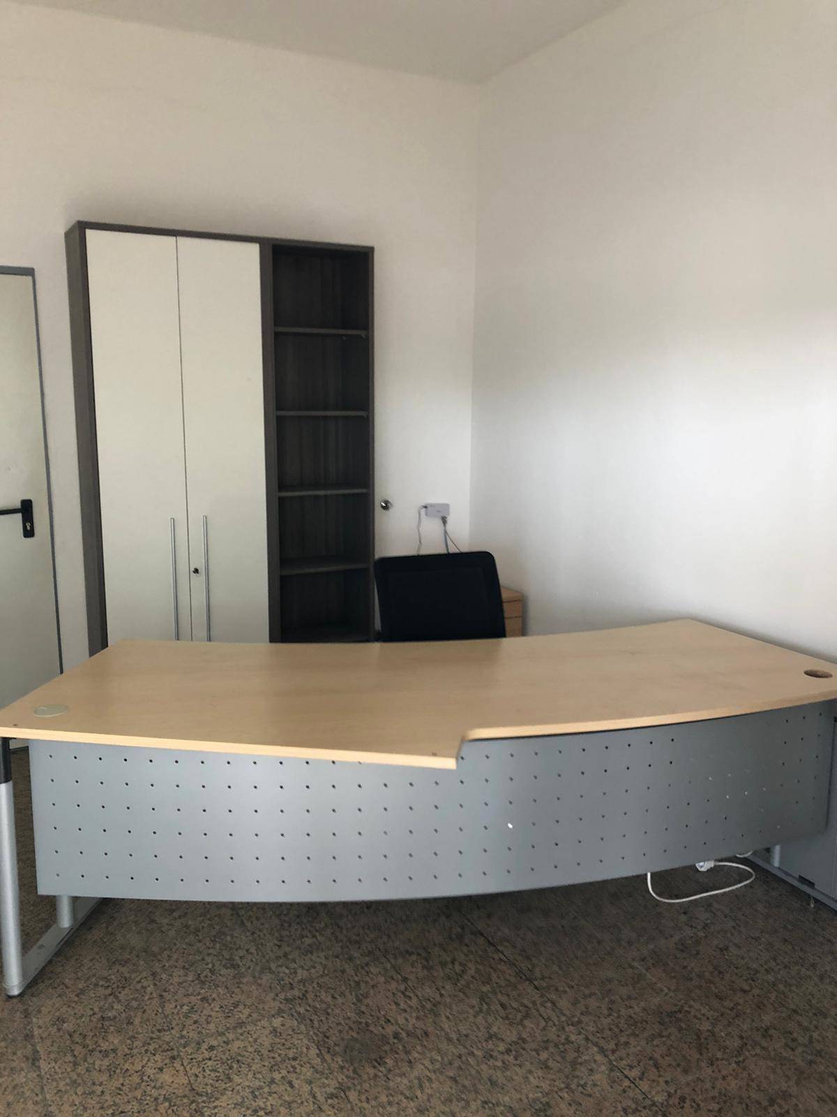 Büroarbeitsplatz mit ergonomischem Schreibtisch, Bürostuhl und einem kombinierten Schrank-Regal-System.