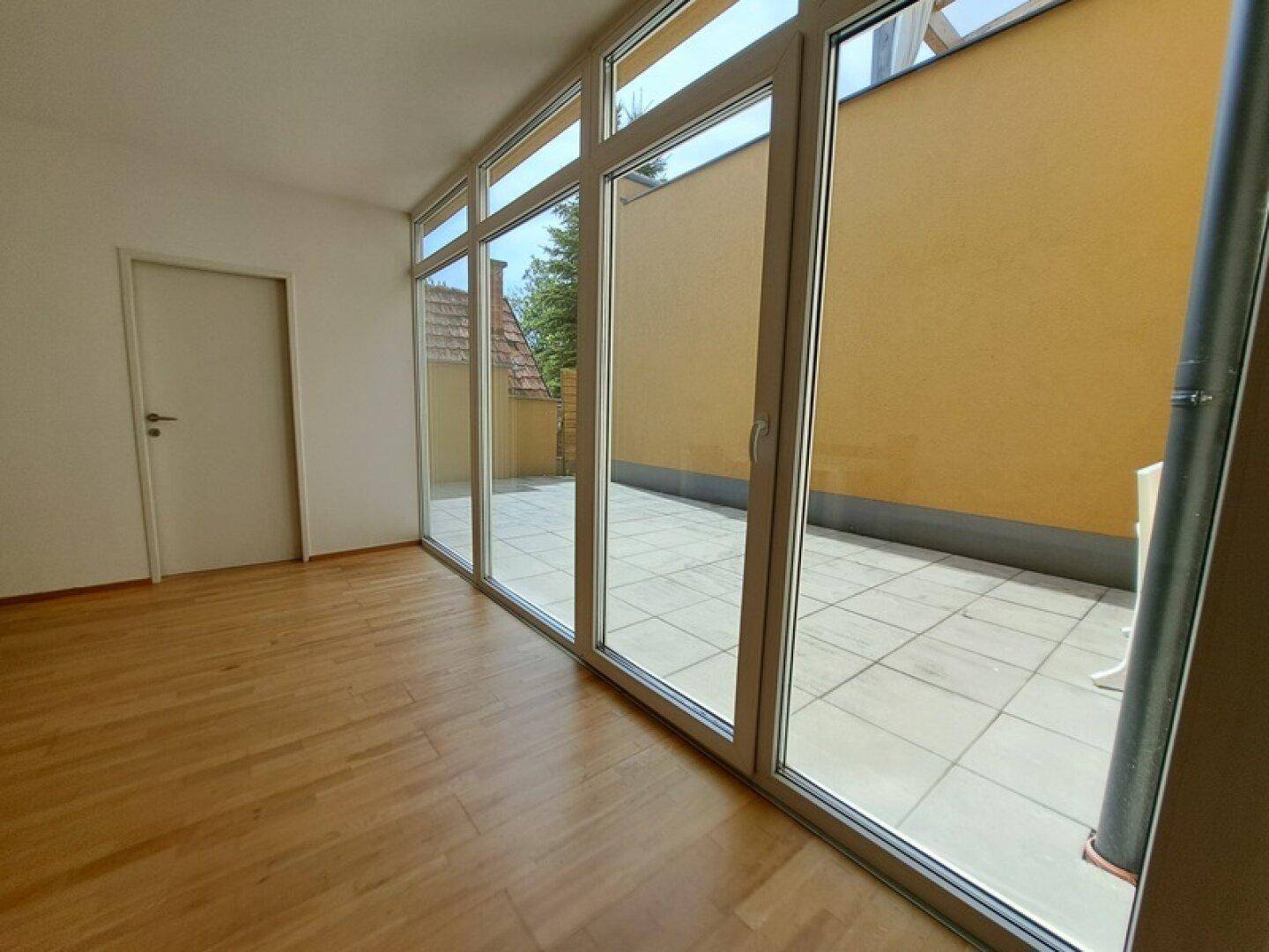 Lichtdurchfluteter Essbereich mit Holzboden und breiter Fensterfront zur sonnigen Terrasse.