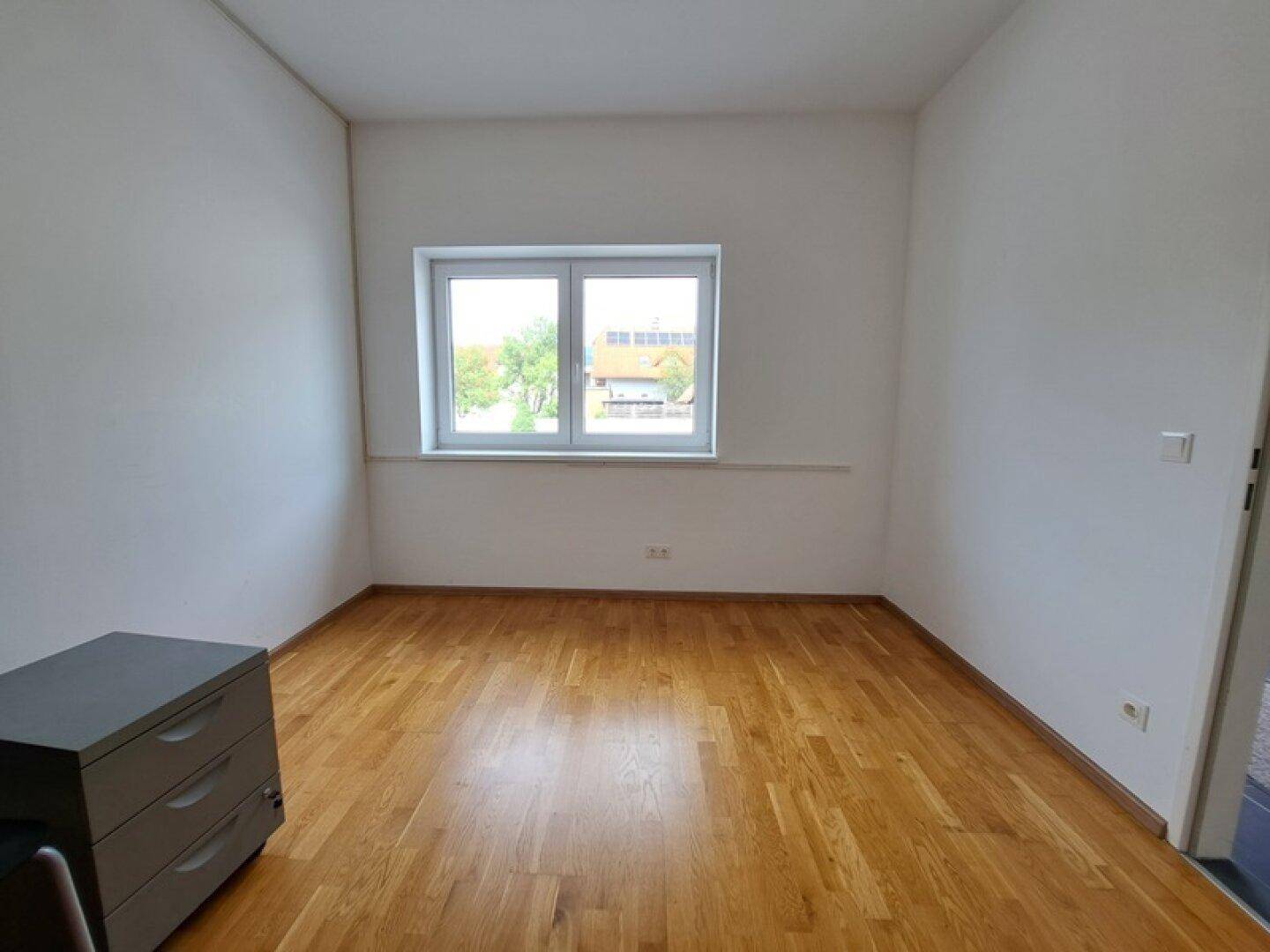 Heller Raum mit Holzboden und Fenster, ideal als Büro oder Arbeitszimmer nutzbar.