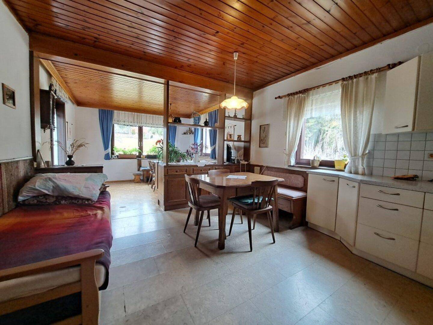 Traditionelle Küche mit Holzdecke, Essbereich und Blick auf den Garten.