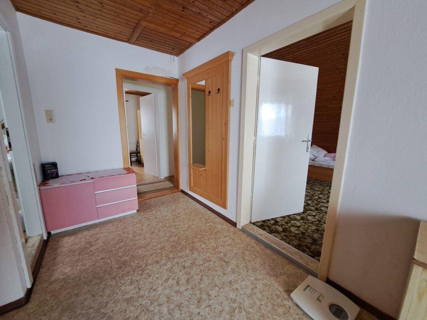 Eingangsbereich mit Garderobe, Kommode und Zugang zu verschiedenen Zimmern.