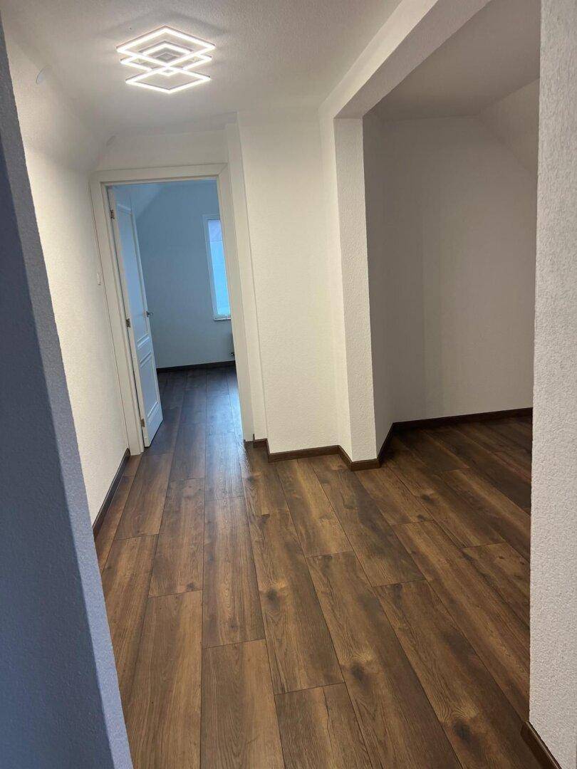 Heller Flur mit Holzboden und Zugang zu mehreren Zimmern im Obergeschoss des Hauses.