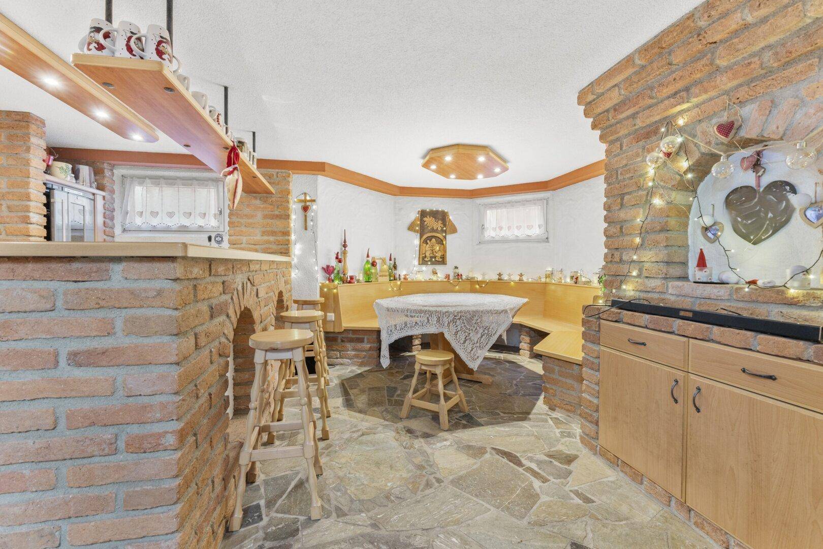 Rustikaler Kellerraum mit Ziegelwänden, Steinboden und einer gemütlichen Bar.