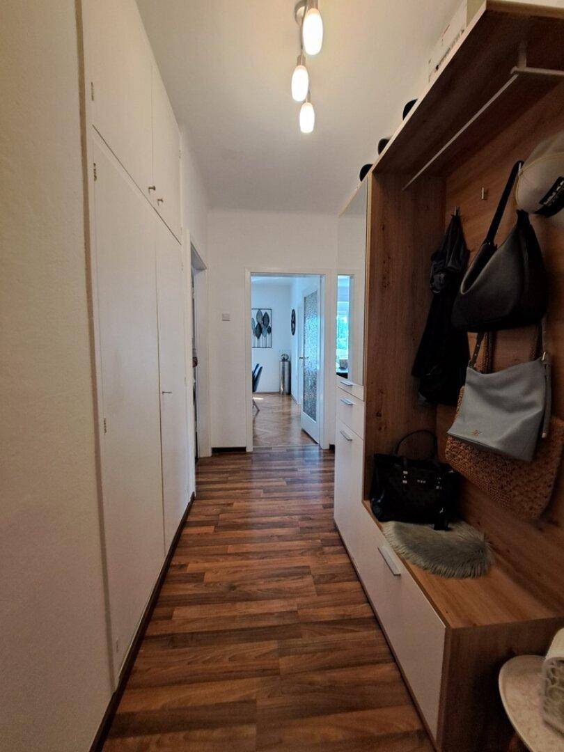 Heller Flur mit praktischen Einbauschränken und einer Garderobe mit Sitzbank, bietet viel Stauraum.