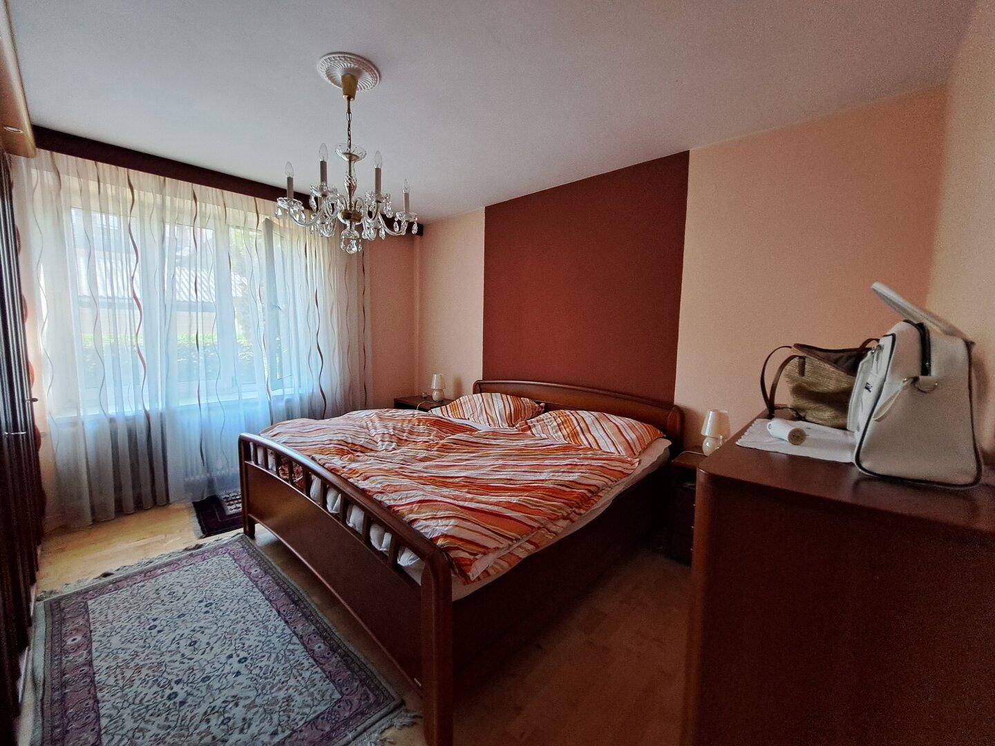 Gemütliches Schlafzimmer mit Doppelbett, Holzboden und Kronleuchter.