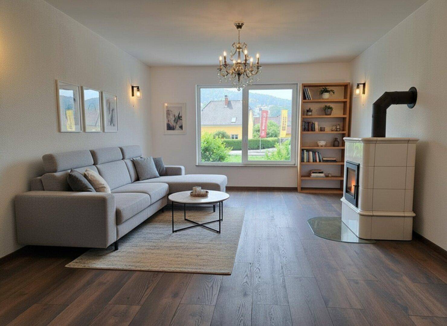 Helles Wohnzimmer mit modernem Kaminofen, bequemer Couch und dunklem Holzboden.