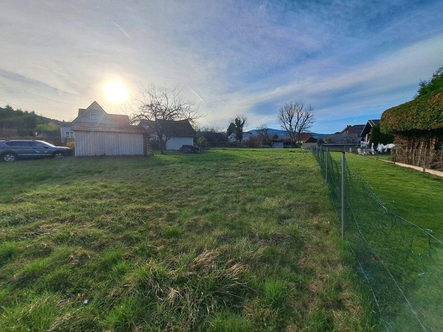 Sonniges Grundstück mit weitläufiger Rasenfläche und idyllischem ländlichen Ausblick.