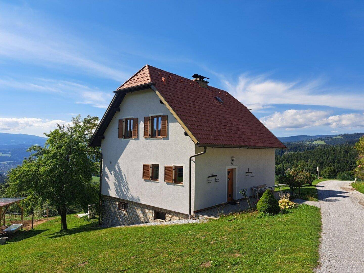 Freistehendes Haus mit rotem Ziegeldach und weitem Blick über die Landschaft.