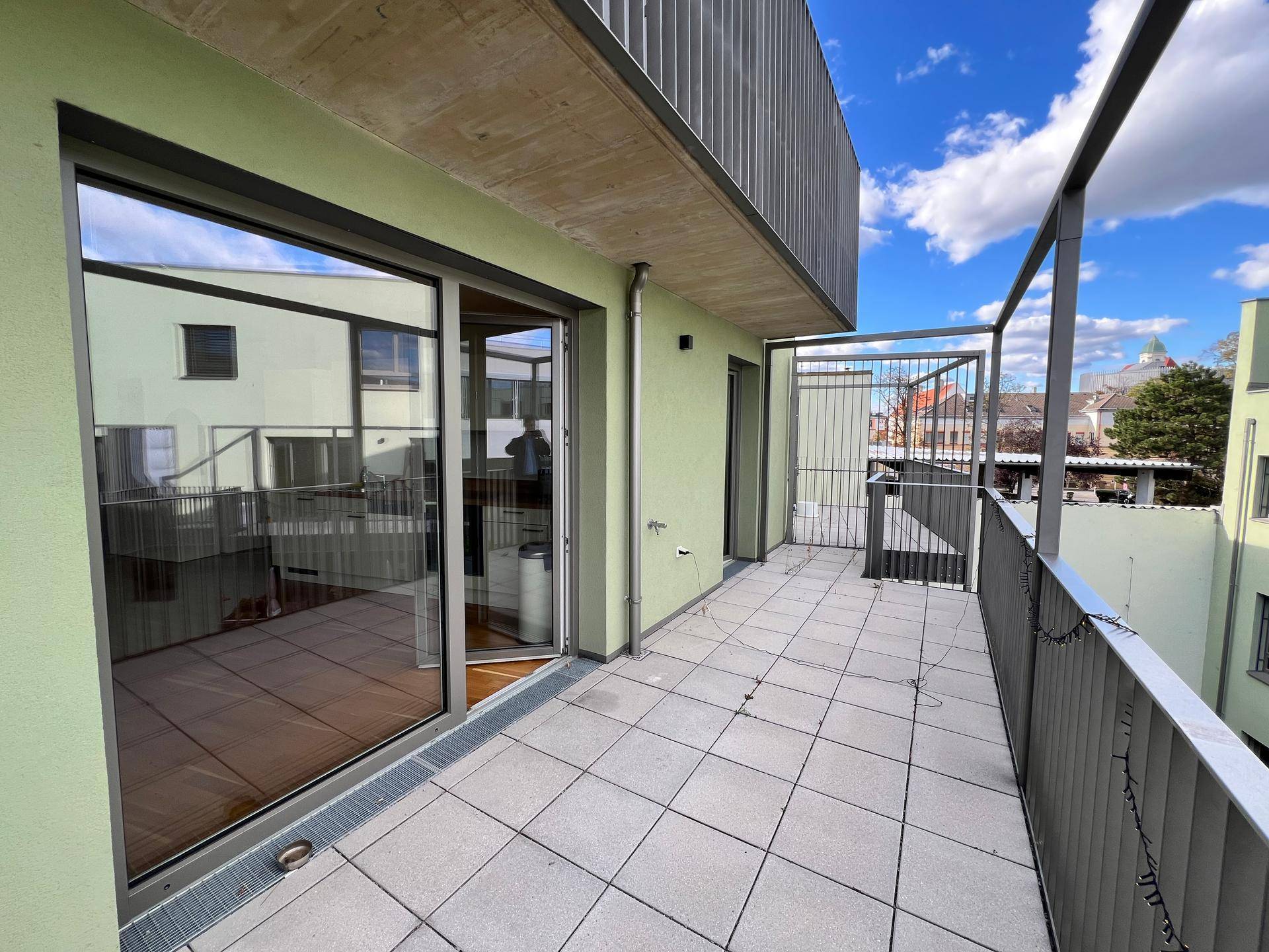 Heller Balkon mit Fliesenboden und großzügigem Zugang zum Innenbereich der Wohnung.