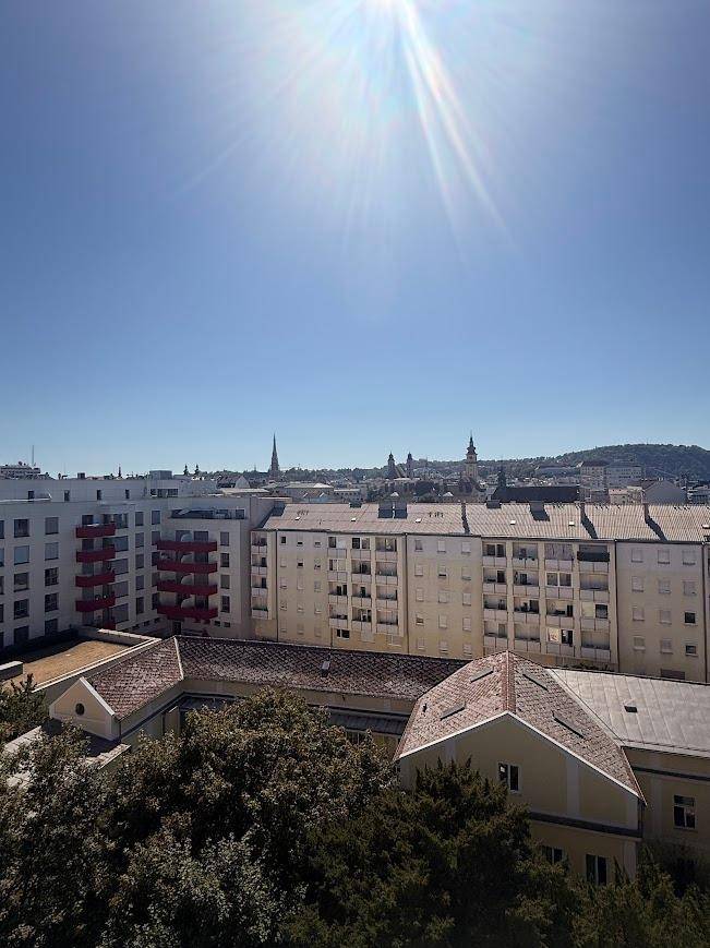 Panoramablick über die Stadt mit zahlreichen Gebäuden und einem sonnigen Himmel.