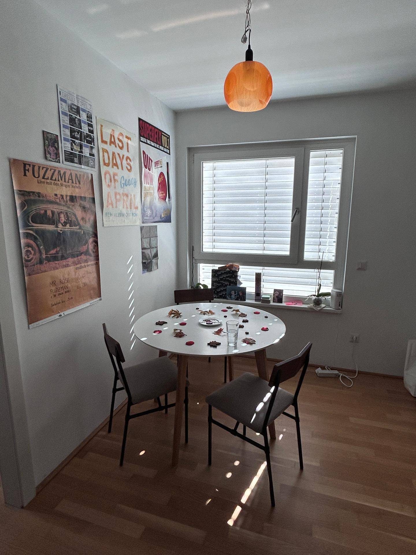 Gemütlicher Essbereich mit rundem Tisch, Stühlen und einem Fenster für natürliches Licht.