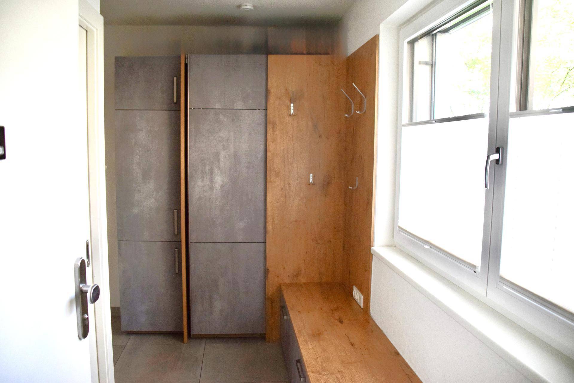 Funktionaler Flur mit Einbauschränken, Sitzbank und Garderobe für den Eingangsbereich.