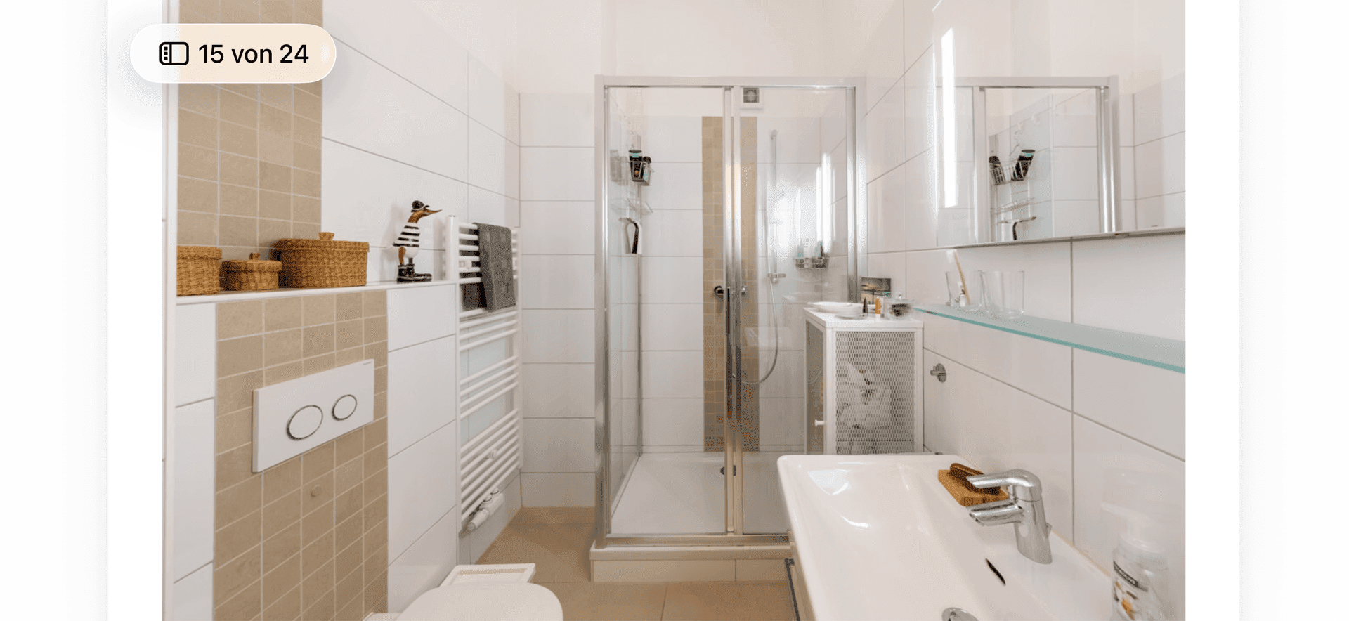 Modernes Badezimmer mit Dusche, WC, Waschbecken und beheiztem Handtuchhalter.